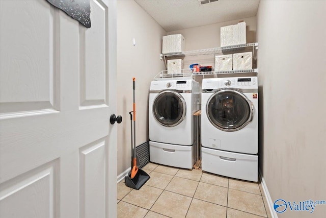 laundry room featuring washer and dryer and light tile patterned floors