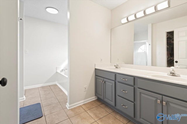 bathroom featuring a tub to relax in, tile patterned flooring, and vanity