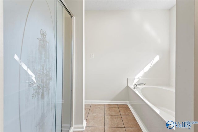 bathroom with tile patterned floors and a bath