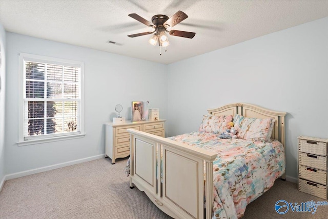 carpeted bedroom with ceiling fan and a textured ceiling