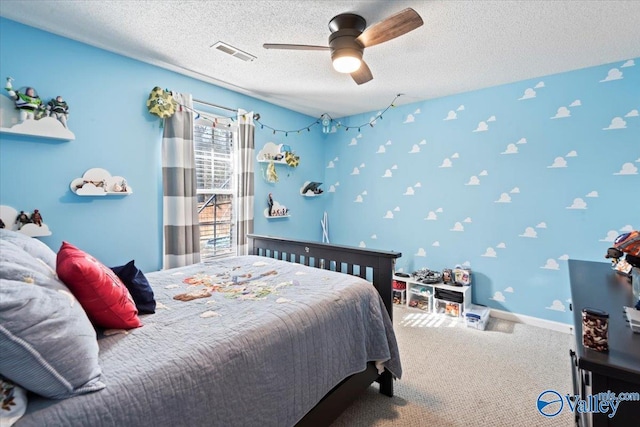 bedroom with ceiling fan, carpet, and a textured ceiling