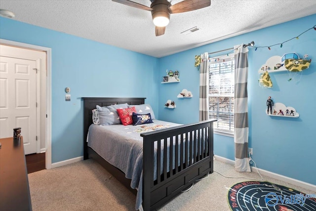 carpeted bedroom with ceiling fan and a textured ceiling