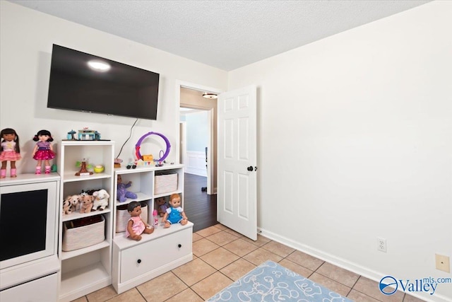 game room with light tile patterned floors and a textured ceiling