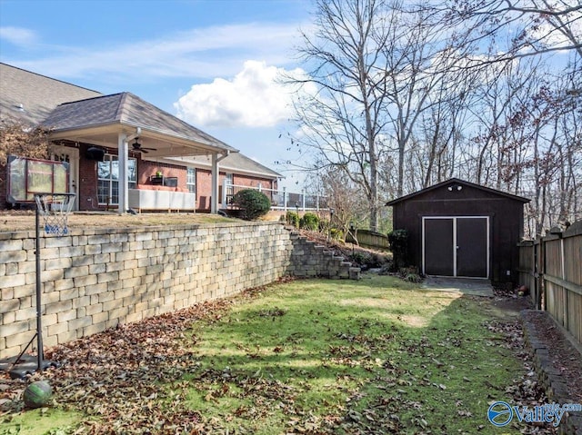 view of yard featuring ceiling fan and a storage shed