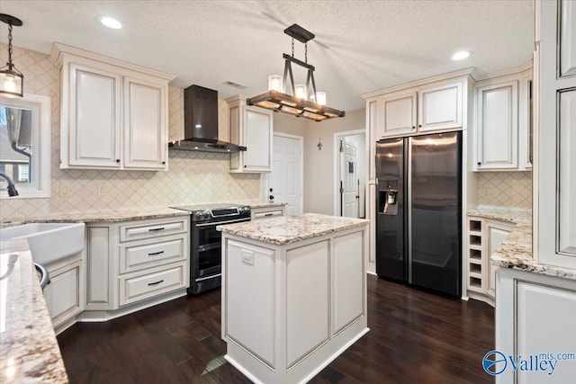 kitchen with electric stove, refrigerator with ice dispenser, pendant lighting, wall chimney range hood, and a center island