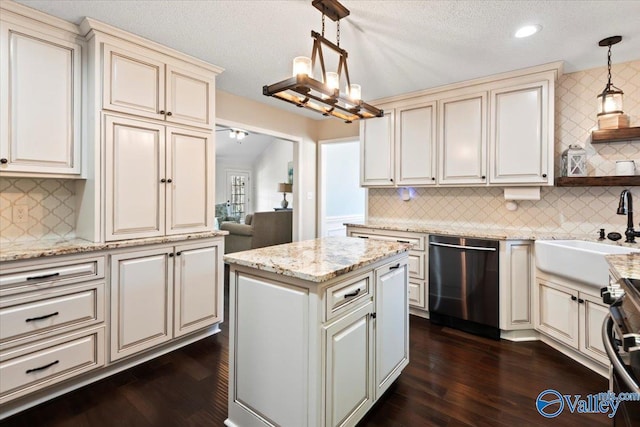 kitchen with sink, decorative light fixtures, cream cabinetry, decorative backsplash, and appliances with stainless steel finishes