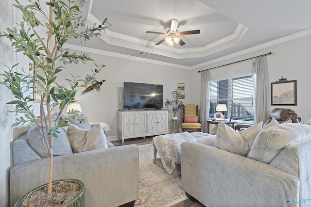 living room with crown molding, ceiling fan, and a raised ceiling