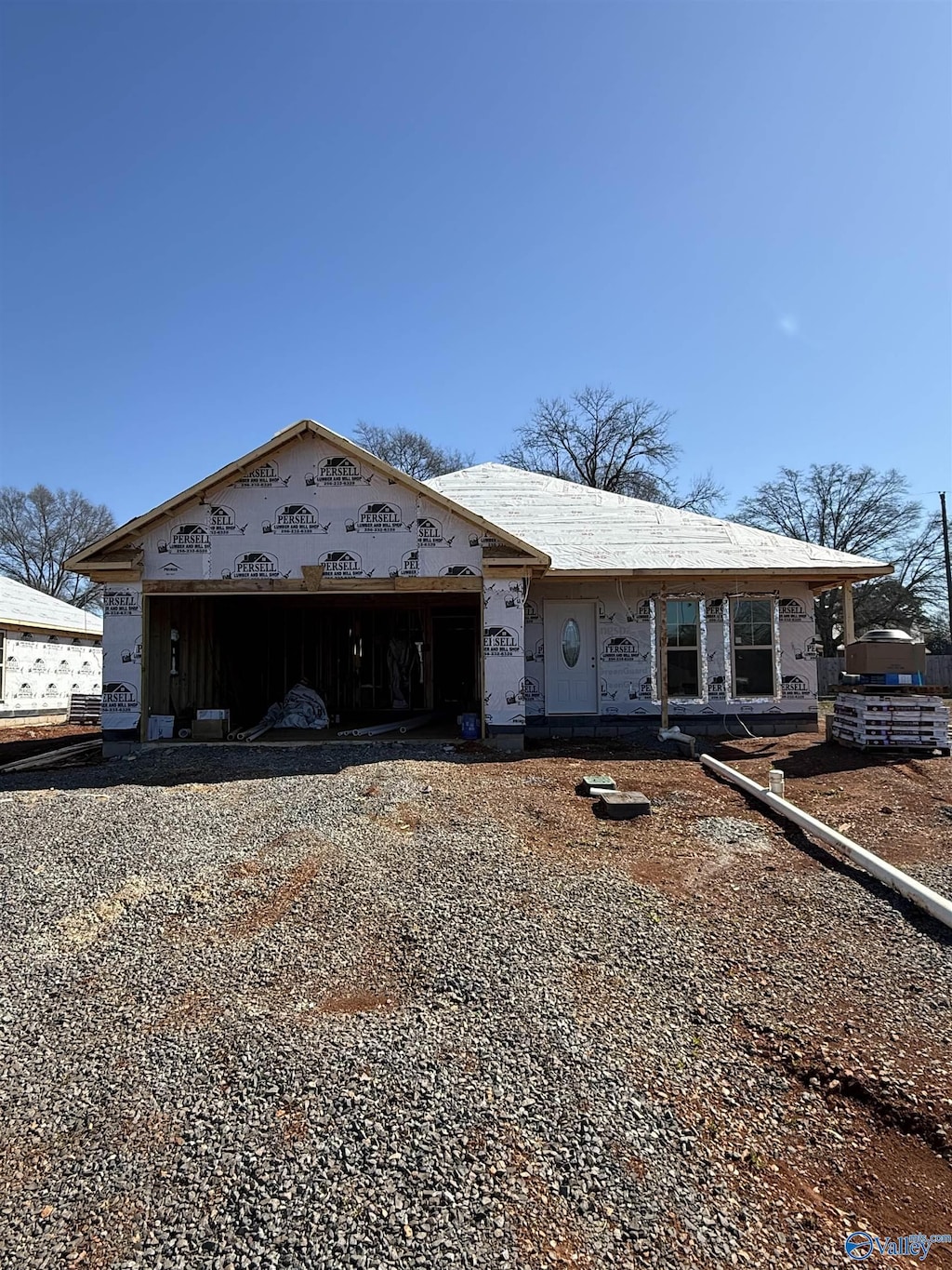 property in mid-construction featuring gravel driveway and a garage