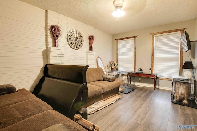 living room featuring hardwood / wood-style floors, a textured ceiling, and ceiling fan