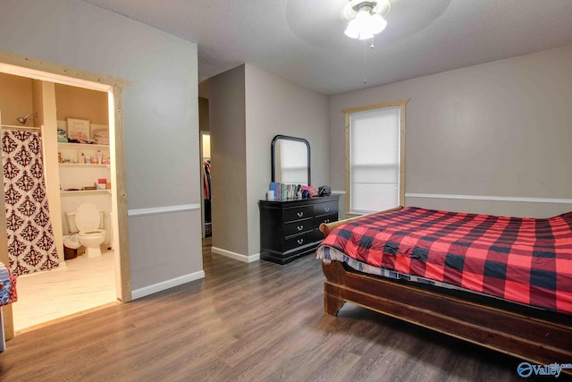 bedroom featuring ensuite bath, ceiling fan, dark wood-type flooring, and a textured ceiling