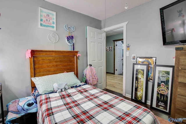 bedroom featuring hardwood / wood-style flooring and a textured ceiling