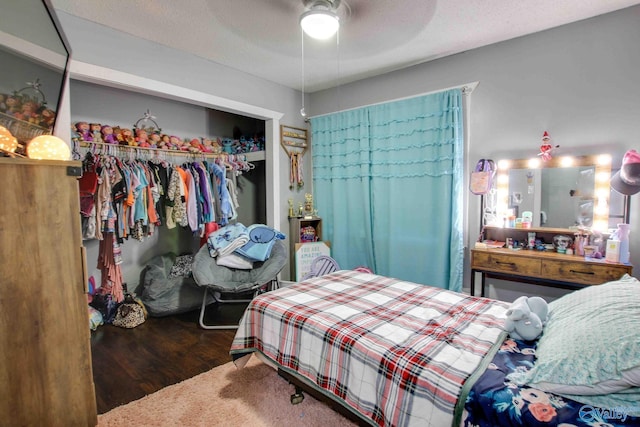 bedroom with a textured ceiling, a closet, dark wood-type flooring, and ceiling fan