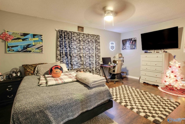 bedroom with a textured ceiling, hardwood / wood-style flooring, and ceiling fan