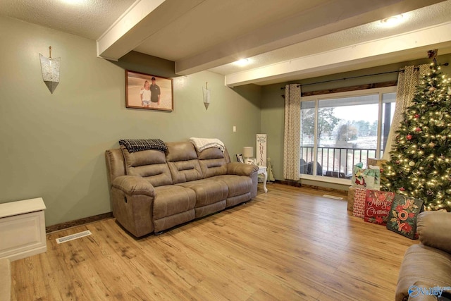 living room featuring beam ceiling and light wood-type flooring