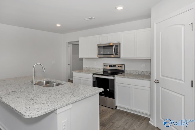 kitchen with stainless steel appliances, light stone countertops, sink, and white cabinets