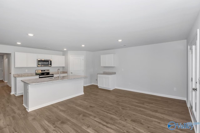 kitchen featuring white cabinetry, sink, stainless steel appliances, and an island with sink