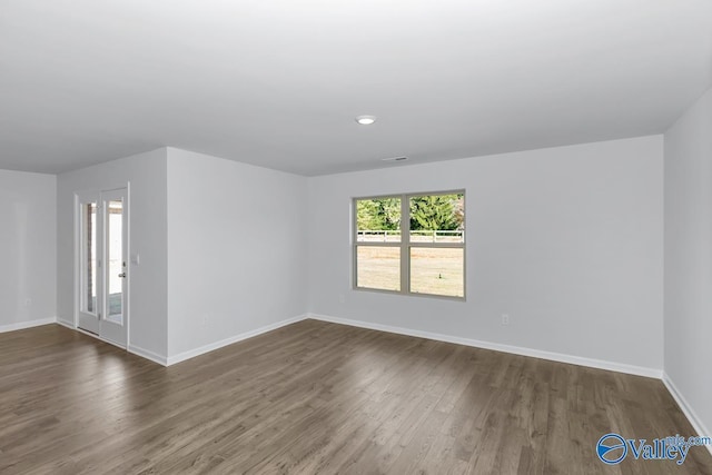 empty room with dark hardwood / wood-style flooring