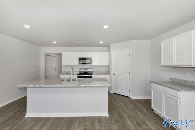 kitchen featuring stainless steel appliances, white cabinetry, sink, and an island with sink