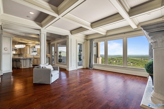 unfurnished living room with dark hardwood / wood-style flooring, decorative columns, and coffered ceiling