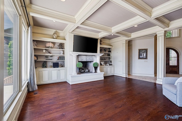 unfurnished living room featuring coffered ceiling, hardwood / wood-style flooring, a premium fireplace, and ornate columns