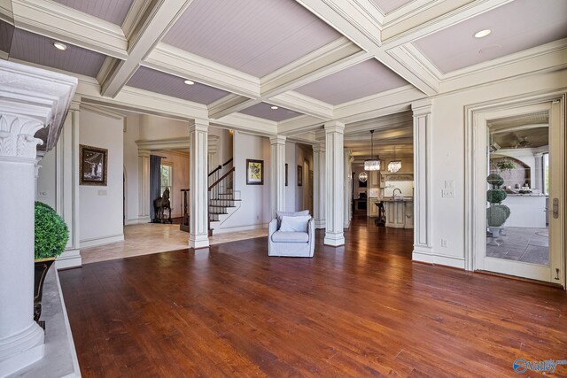 unfurnished living room with beam ceiling, crown molding, decorative columns, hardwood / wood-style floors, and coffered ceiling