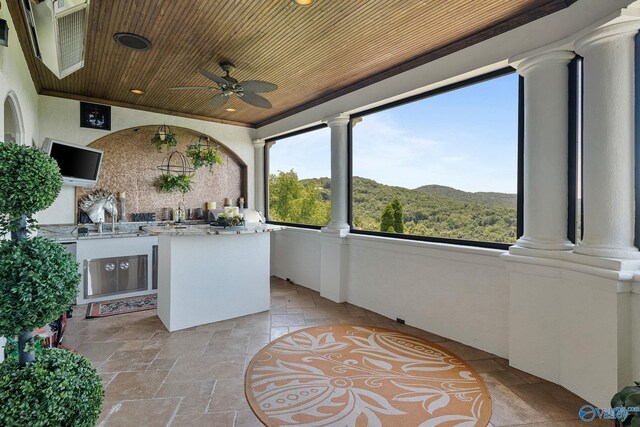 view of patio with exterior kitchen, ceiling fan, a mountain view, and sink