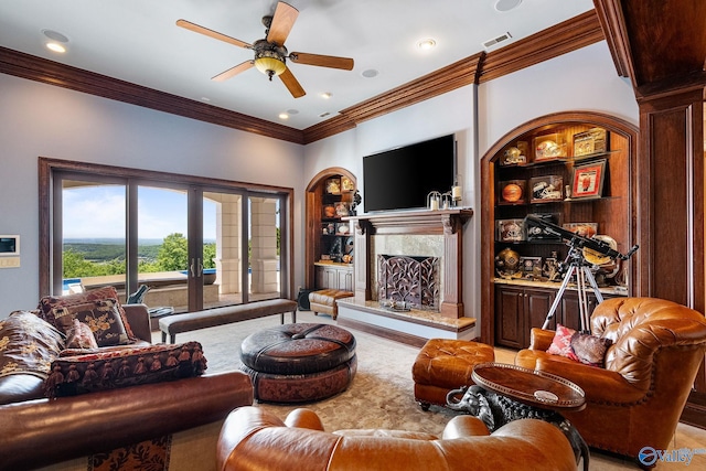 living room featuring built in shelves, ceiling fan, ornamental molding, and a fireplace