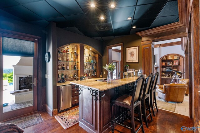 bar featuring light stone counters, dark wood-type flooring, and a paneled ceiling