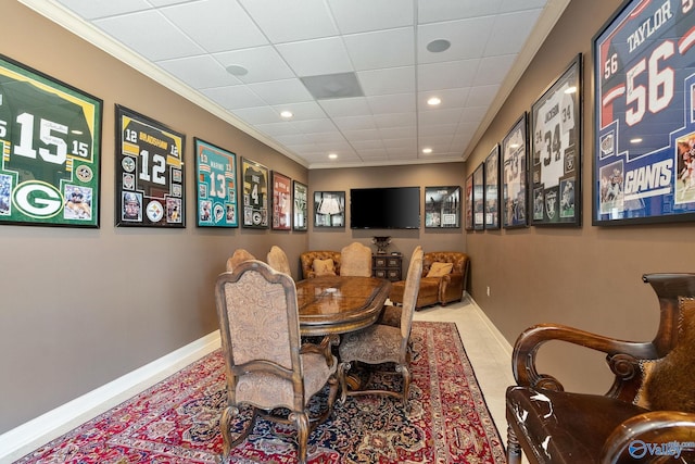 tiled dining space featuring ornamental molding and a paneled ceiling