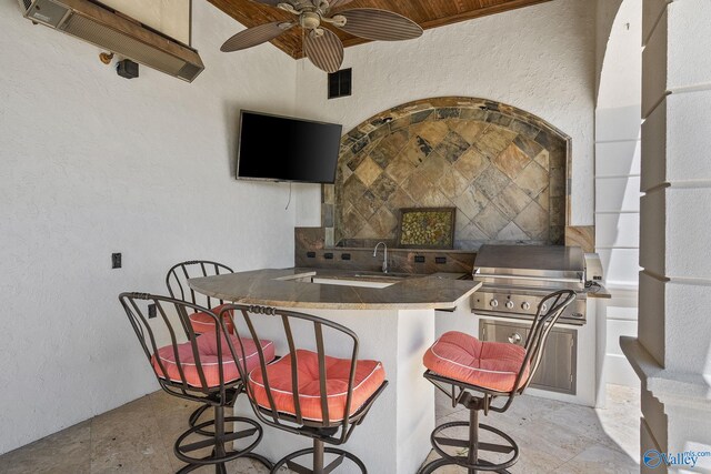 kitchen with sink, ceiling fan, and a kitchen breakfast bar