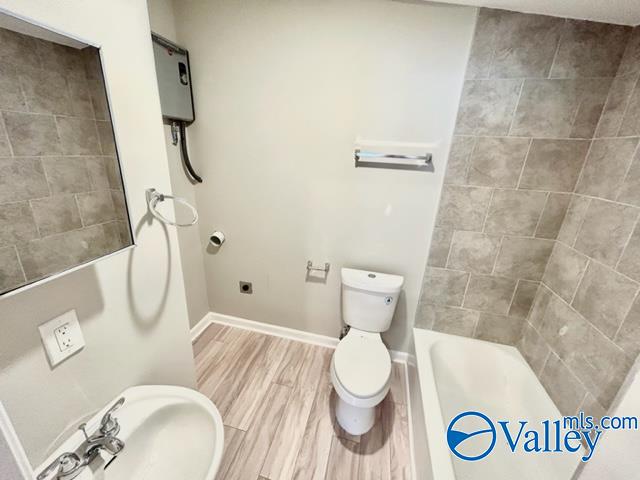 bathroom featuring toilet, hardwood / wood-style flooring, sink, and a washtub