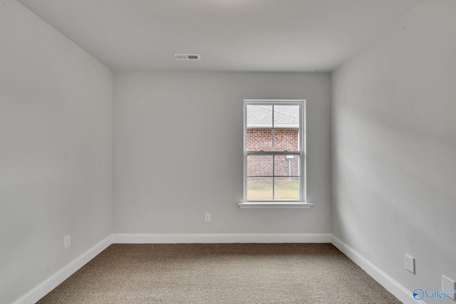 empty room with baseboards, visible vents, and carpet floors