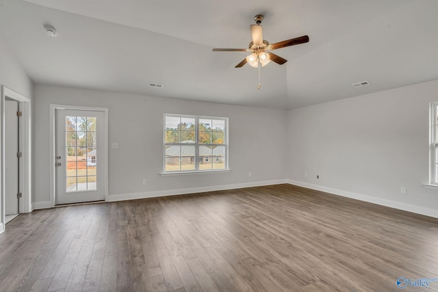 unfurnished living room featuring lofted ceiling, visible vents, baseboards, dark wood-type flooring, and a ceiling fan