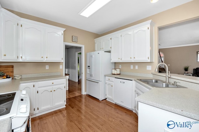 kitchen featuring sink, white cabinets, white appliances, and light wood-type flooring