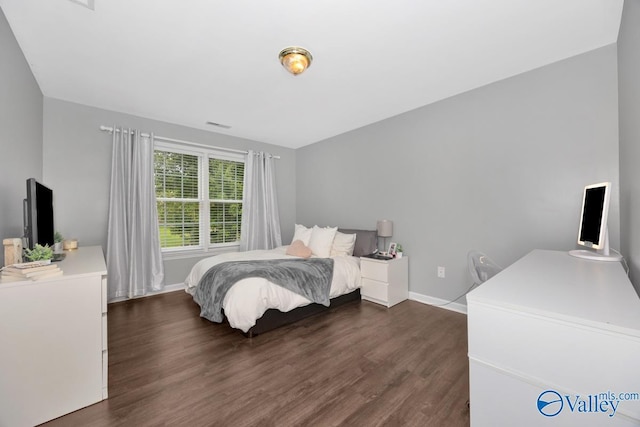 bedroom with dark hardwood / wood-style flooring