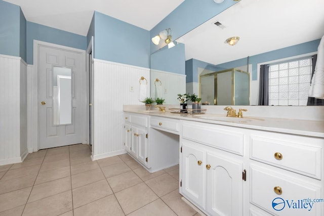 bathroom featuring vanity, a shower with shower door, and tile patterned flooring