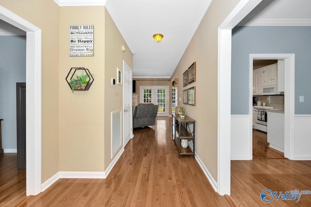 hallway featuring crown molding and light wood-type flooring