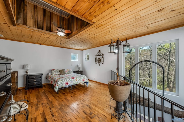 bedroom featuring hardwood / wood-style floors, multiple windows, and wooden ceiling