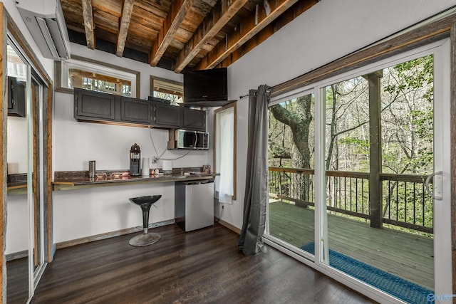 kitchen featuring dark wood-type flooring, stainless steel dishwasher, wooden ceiling, and beam ceiling