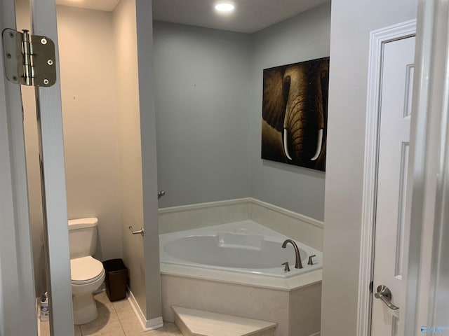 bathroom with tile patterned flooring, a bath, and toilet