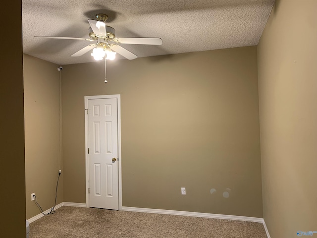 carpeted empty room featuring ceiling fan and a textured ceiling