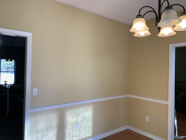 unfurnished room featuring an inviting chandelier