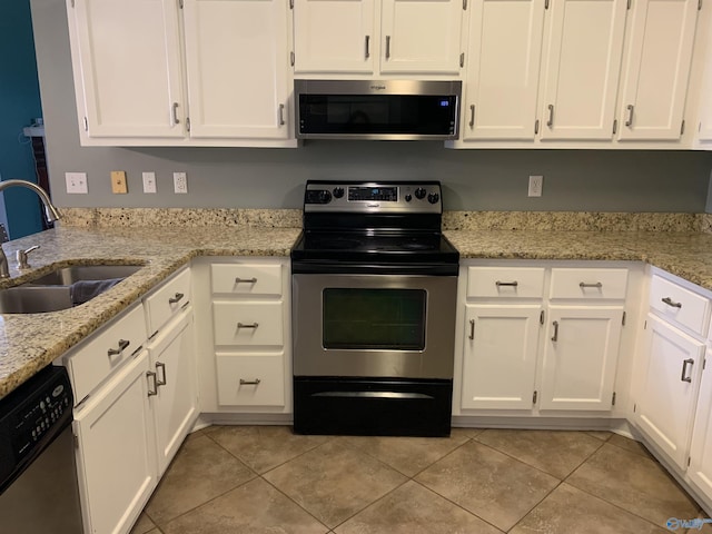 kitchen featuring sink, light tile patterned floors, appliances with stainless steel finishes, white cabinetry, and light stone counters