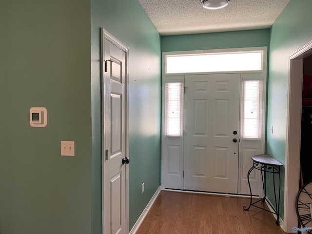 foyer entrance with hardwood / wood-style floors and a textured ceiling