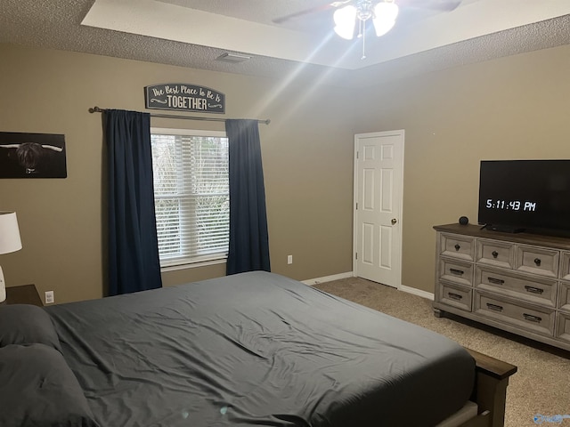 bedroom with ceiling fan, light carpet, and a textured ceiling