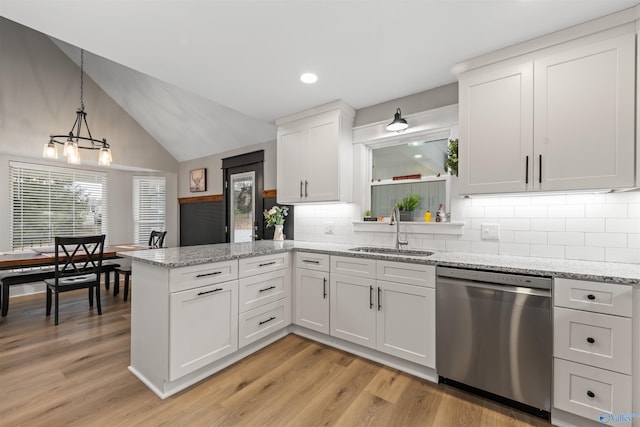 kitchen featuring a sink, light wood-style floors, white cabinets, hanging light fixtures, and stainless steel dishwasher