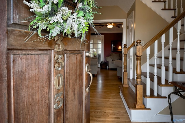 foyer with ceiling fan, stairway, and wood finished floors