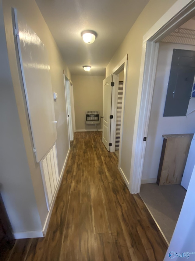 hallway with dark wood-type flooring, electric panel, and heating unit