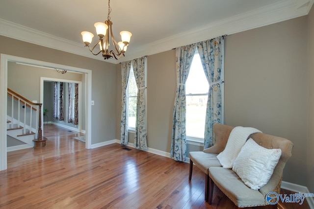 sitting room with wood finished floors, crown molding, baseboards, and stairs