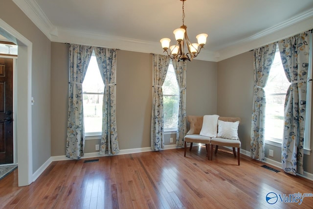 unfurnished room featuring plenty of natural light, wood-type flooring, visible vents, and crown molding